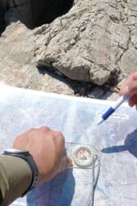 Volunteer learning compass and map navigation techniques during ranger training in Namibia
